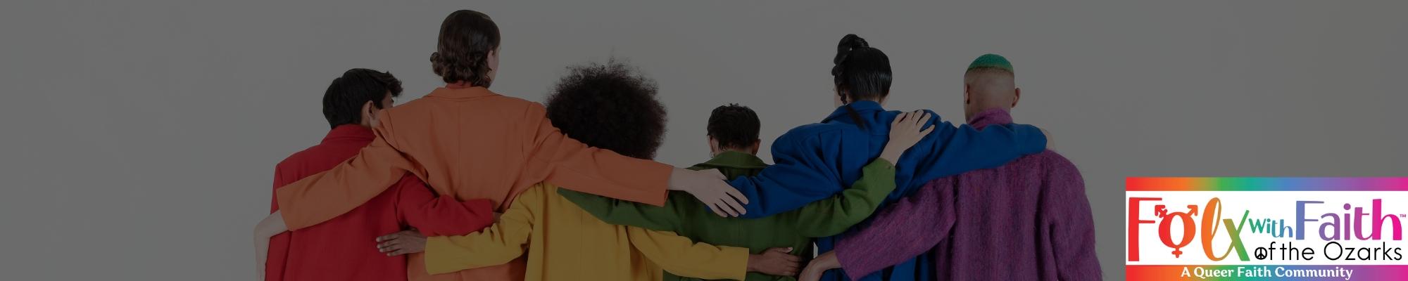 A group of people with their arms around each other in different colored jackets representing the pride flag.