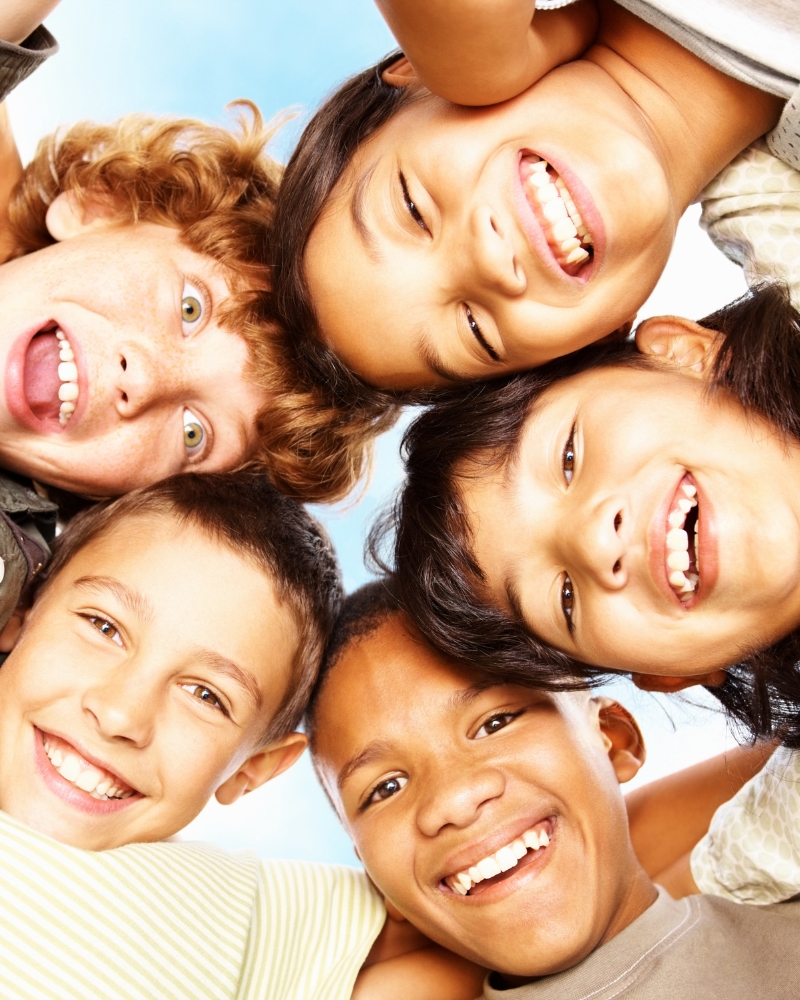 Group of kids looking down at the camera.