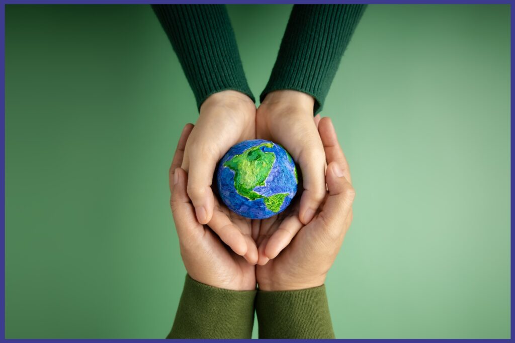 Two people holding their hands out with both of them holding a palm sized globe.