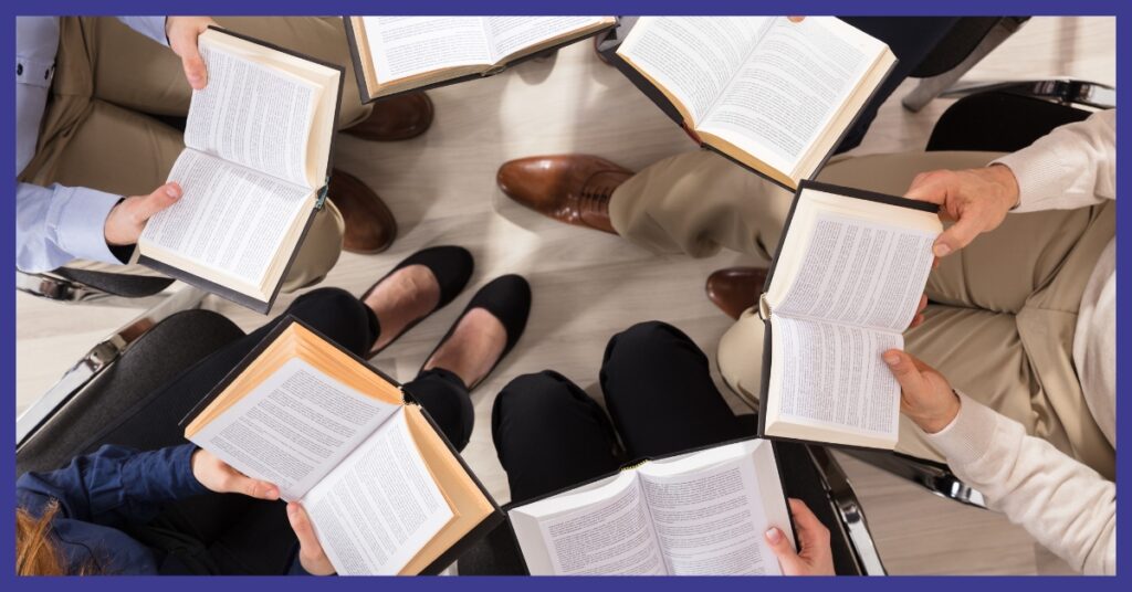 People holding books in a circle.