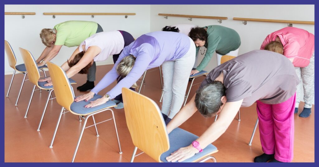 People bending at the waist with their hands on a chair in front of them.